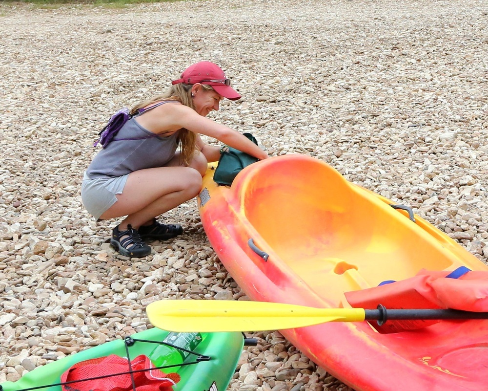 Woman getting kayak ready for floating