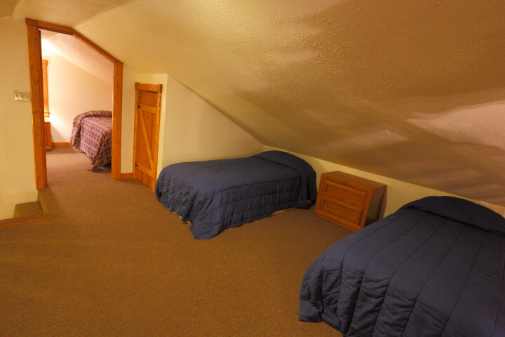 Upstairs living area, with two beds and another bedroom